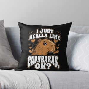 Black throw pillow with capybara graphic, heart accents, and playful text, perfect for home decor and animal lovers.